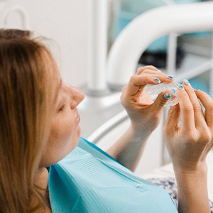 Patient holding clear aligner in treatment room