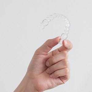 Closeup of patient holding clear aligner