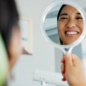 Woman smiling while looking at reflection in mirror