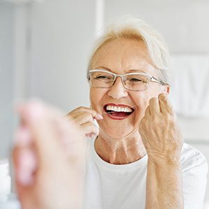 Woman smiling while flossing her teeth
