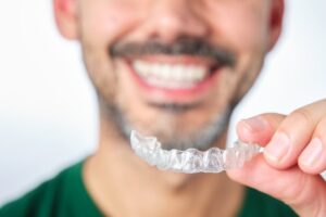 Man smiling after removing his Invisalign